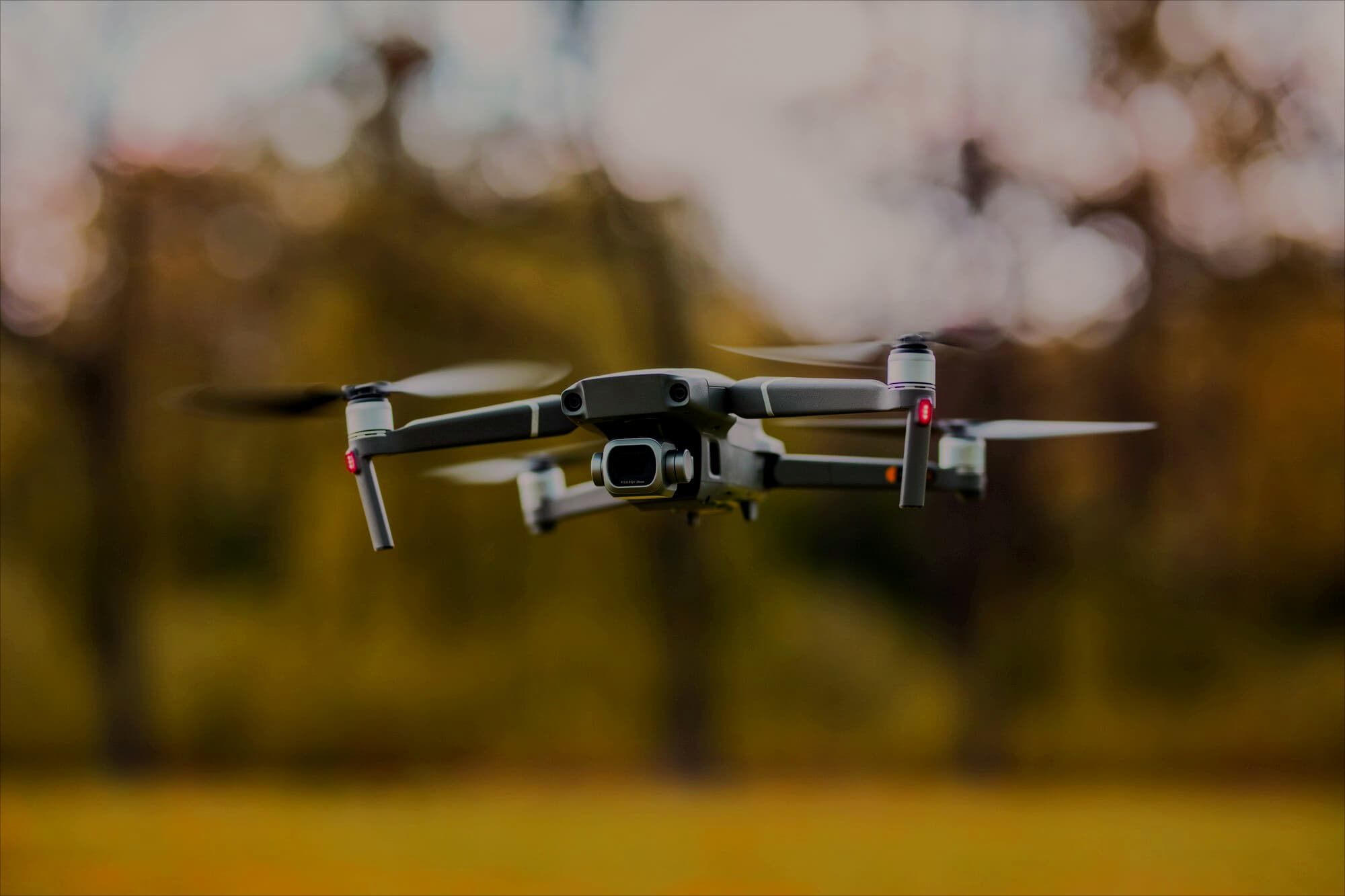 Black quadcopter drone over in the forest VDisain